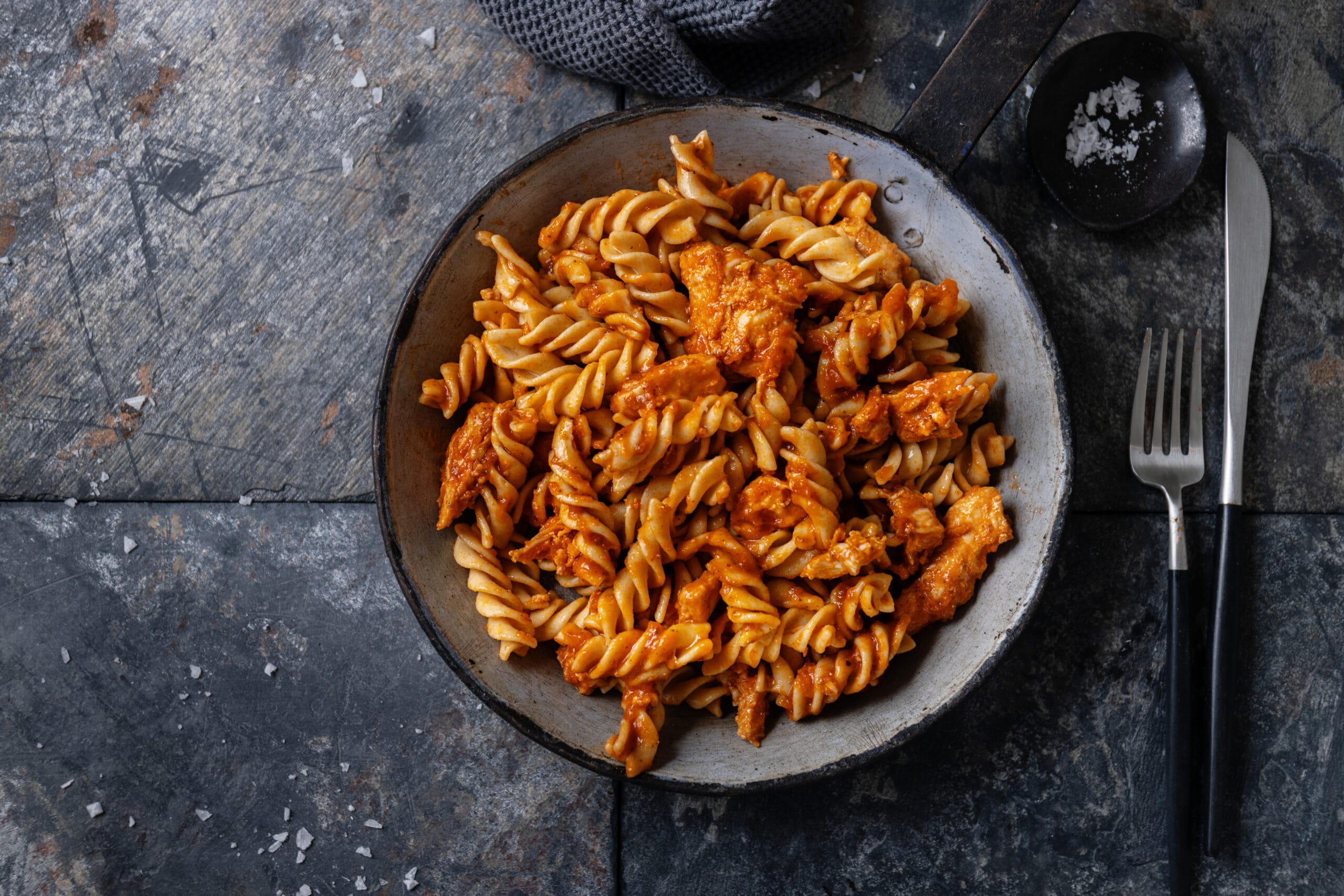 Close-up of ditalini pasta with substitutes such as tubetti, orzo, and small shells, displayed on a wooden surface.