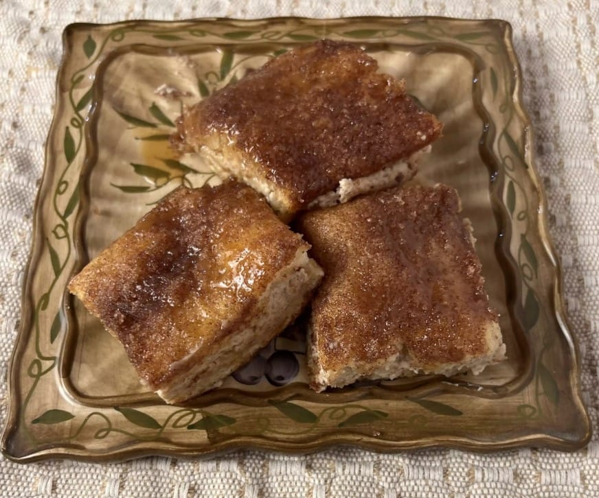 A slice of churro cheesecake topped with cinnamon sugar