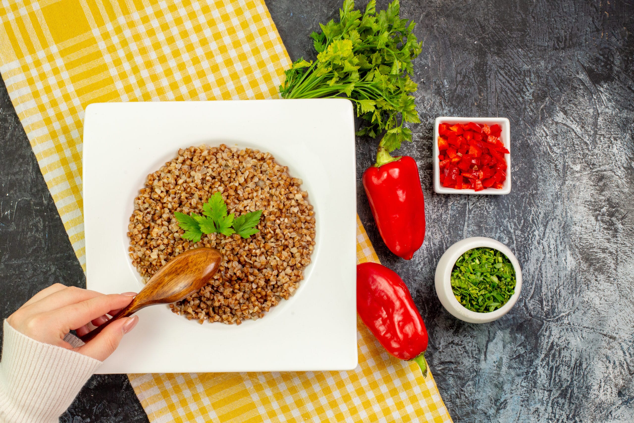 A bowl of cooked orzo with herbs on a wooden table